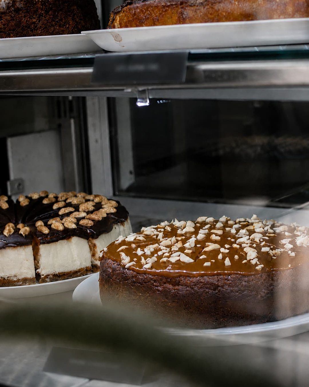 Cakes lined up in the lit display case